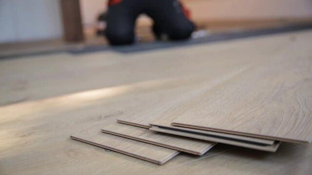 Construction worker installing laminate floor in a new renovated attic. Home improvement concept