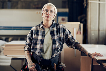 Female carpenter in protective wear at wok