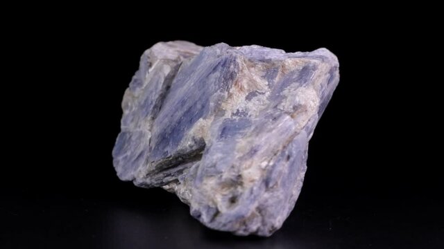 Kyanite (or cyanite) rock slowly rotating over a black background
