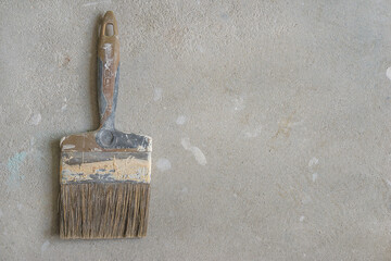 Old paint brush on concrete background