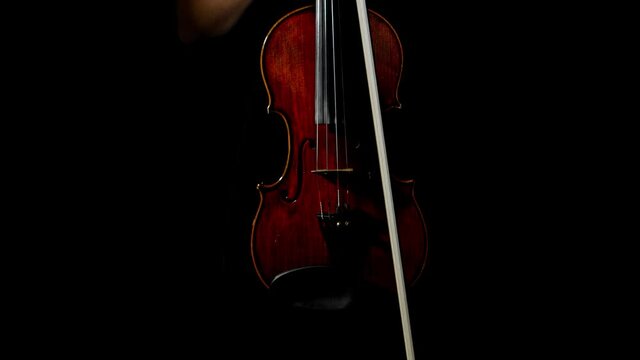 Professional violin in the hands of a violinist. Light in and light out.