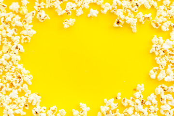 Naklejka na ściany i meble Popcorn on yellow table top-down frame copy space