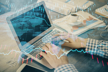 Double exposure of forex graph with man working on computer on background. Concept of market...