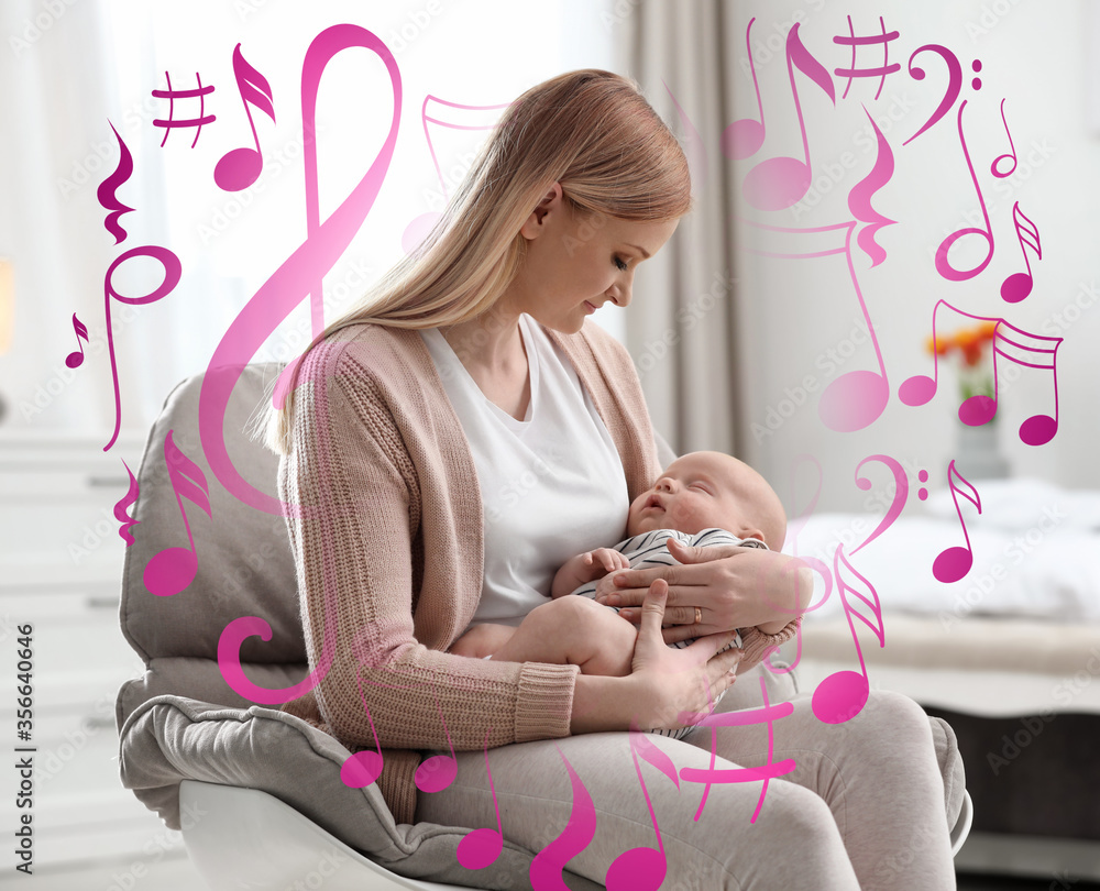 Wall mural Flying music notes and young mother with her little baby sitting in armchair at home. Lullaby songs