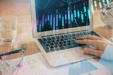 Multi exposure of market chart with man working on computer on background. Concept of financial analysis.
