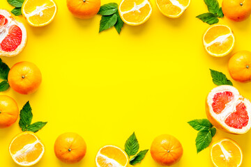 Frame sliced citrus mix on yellow background top view