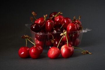Tray with fresh cherry on a gray background.