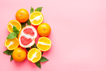 Citrus fruits on pink background top view