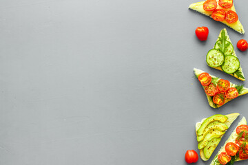 cooking green avocado toasts on grey table top view frame copy space