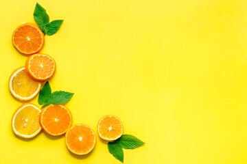 Orange slices with leaves on yellow top view