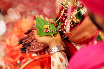 Indian traditional wedding groom and bride holding Manglesutra jewelry in wedding ritual