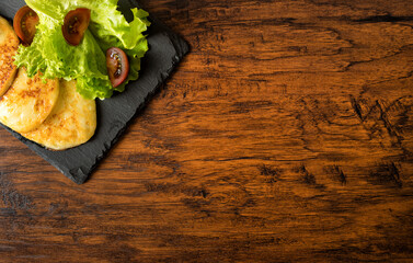 Grilled cheese with vegetables on the plate.