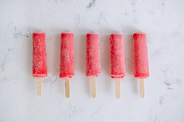 Pink fruit ice sorbet on a white background. Stick ice cream. Flat lay