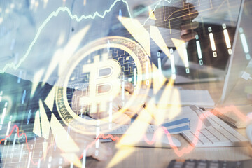 Crypto currency theme hologram with businessman working on computer on background. Concept of...