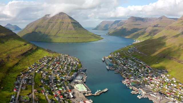4k drone forward video (Ultra High Definition). Sunny summer cityscape of Klaksvik town. Aerial morning scene of Bordoy island, Faroe, Kingdom of Denmark, Europe. Traveling concept background.
