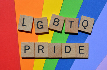 Pride LGBTQ, words in 3d wooden alphabet letters isolated on rainbow coloured background