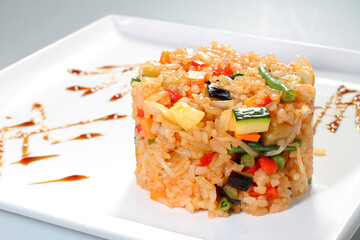 Boiled rice with vegetables on a white plate