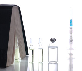medical ampoules on a white background with a book.