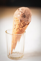 Chocolate ice cream in a waffle cone in a glass