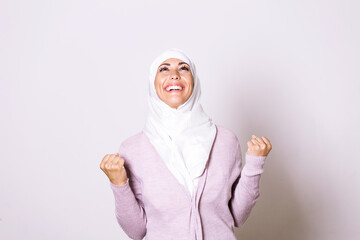 Beautiful muslim woman wearing hijab celebrating for good news. Beautiful young Muslim woman...