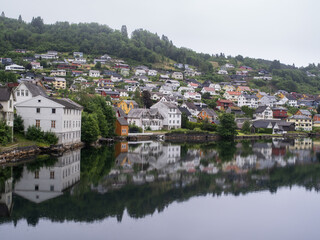 Fototapeta na wymiar Cloudy summer view of Hardangerfjord and Norheimsund village, Norway, Europe