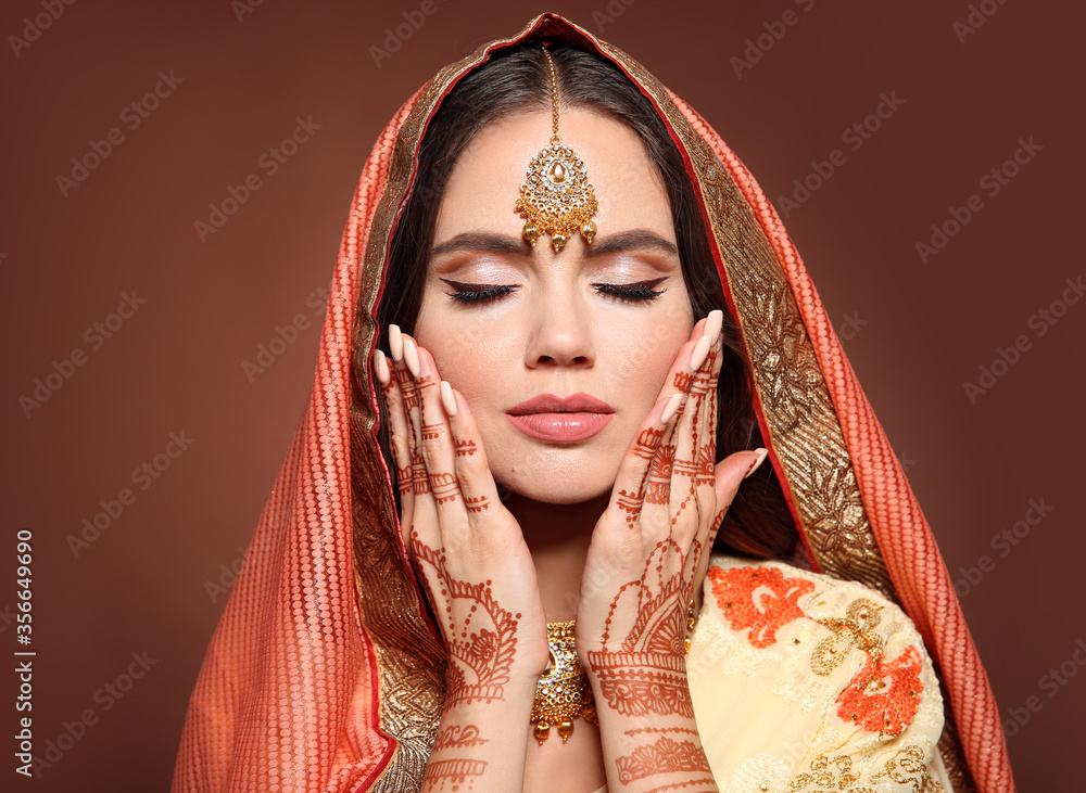 Wall mural mehndi. portrait of beautiful indian girl in saree. young hindu woman model with kundan golden jewel