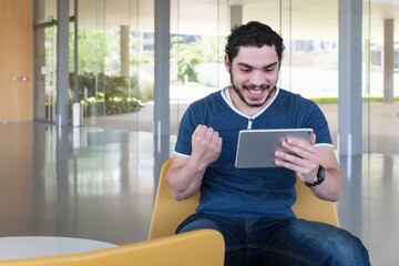 Excited young men checking tablet content