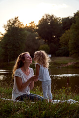 Mom and daughter on the street are looking at each other. Laughter and joy of a woman and a child. High quality photo