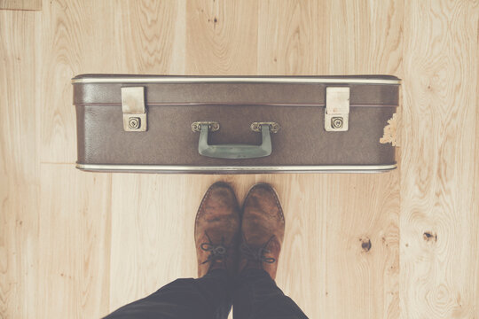 Looking Down Towards A Persons Feet And Old Vintage Travel Suitcase