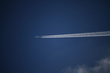 Plano de la estela de un avión, sobre cielo azul