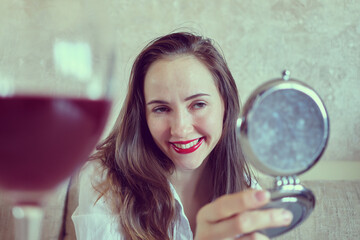 Drunk woman looking in a pocket mirror.