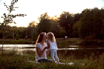 Mom and daughter on the street are looking at each other. Laughter and joy of a woman and a child. High quality photo