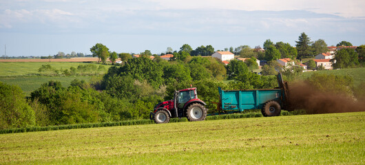 Agriculteur au volant de son tracteur pour épandre du lisier dans les champs.