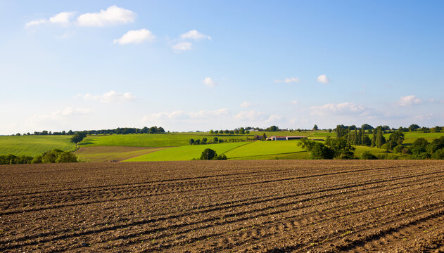 Paysage de campagne, agriculture et champ labouré par un agriculteur en France.