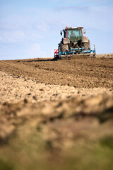 Tracteur travaillant la terre au champ, paysage de campagne.
