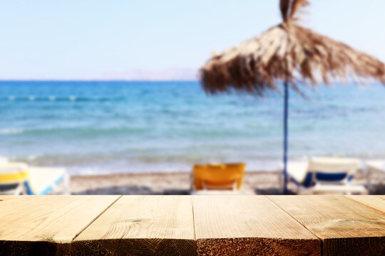 background Image of wooden table in front of tropical beach. Ready for product display