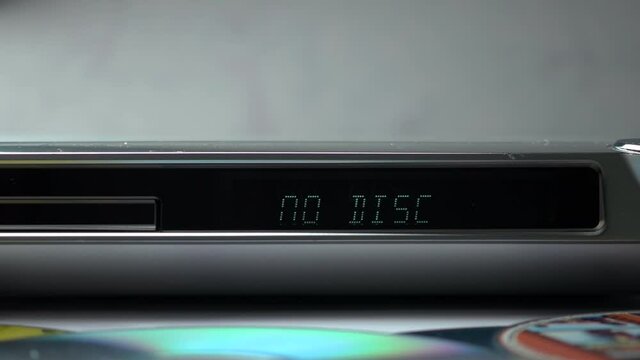 DVD Player Display. Eject Tray And Insert Disc In DVD-player. Male Hand Loading Disc Into The Device DVD/CD Player.  .