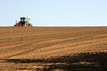 Fototapeta premium Agriculteur dans son tracteur qui travail la terre en France.