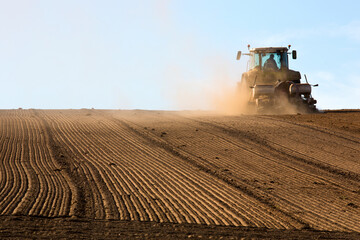 Tracteur en campagne qui laboure la terre en été.