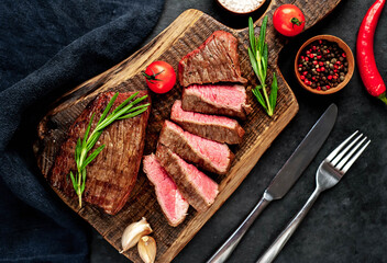 
Two grilled beef steaks with spices on a stone background