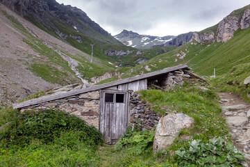 Naklejka premium An old shepherd shelter with a view of Grossglockner. Hiking travel outdoor concept, journey in the mountains, Kals am Grossglockner, Austria.