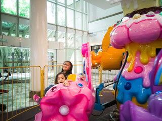 Putrajaya, Malaysia - Oct 2019 : Children riding an indoor amusement ride at Alamanda Mall.
