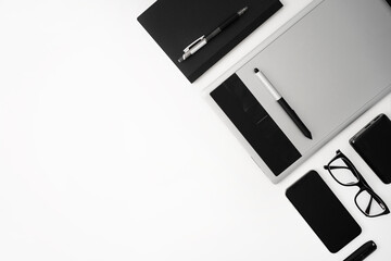 Top view white work desk. Workspace with notebook, pen, tablet, glasses, mobile phone, flash drive...