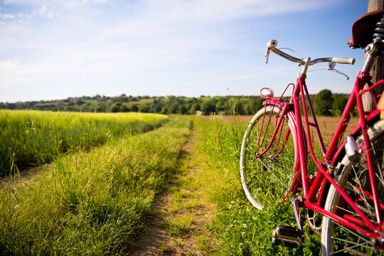 Bicyclette rouge en campagne au bord d'un chemin au printemps.