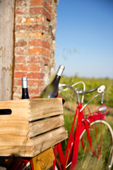Bouteilles de vin à l'arrière du vieux vélo rouge d'un viticulteur dans une caisse en bois.