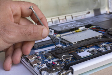 Computer service. Hardware engineer repairs mother board of modern laptop. Computer upgrade. Manufacturer guarantee.