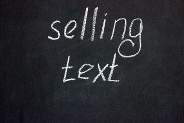 
The inscription on the blackboard with white chalk "selling text". Copywriting activity