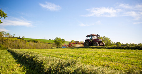 Tracteur ou moissonneuse fauchant les prés pour faire du foin.