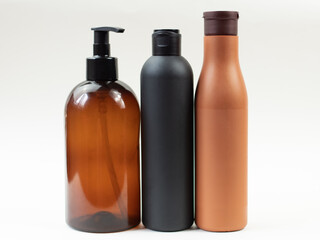 dark plastic cosmetic bottles on a light background