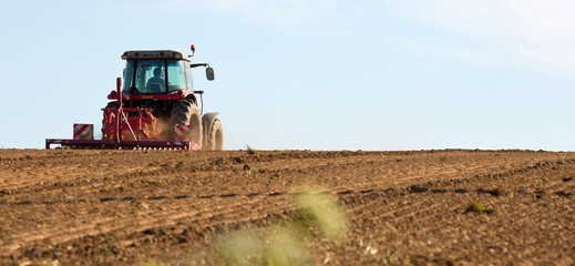 Tracteur dans un champ en train de semer du maïs.